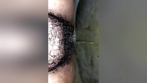 Busty girl with hairy pussy pissing in amateur porn video